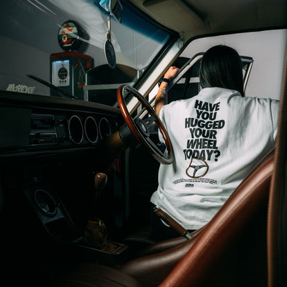 Model Wearing Have_You_Hugged_Your_Wheel_Today_White_Heavy_Faded_T-Shirt_Showing The Back_Print